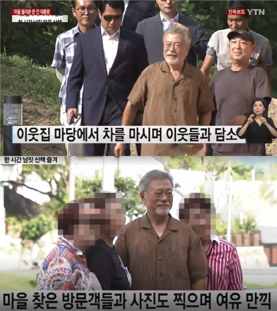 문재인 전 대통령이 지난 22일 양산 평산마을을 찾은 방문객들과 사진을 찍고 있다. 이날 경호구역 확대로 사저 인근이 조용해지자 문 전 대통령은 1시간 가량 마을 나들이에 나섰다. <YTN 방송화면>